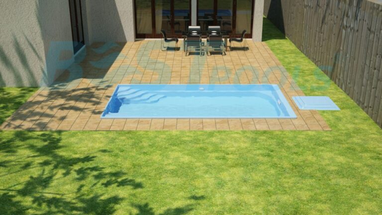 Scena na podwórku z małym prostokątnym basenem otoczonym wyłożonym kafelkami patio, zieloną trawą i stołem jadalnym z krzesłami w pobliżu domu. Drewniany płot biegnie wzdłuż jednej strony.