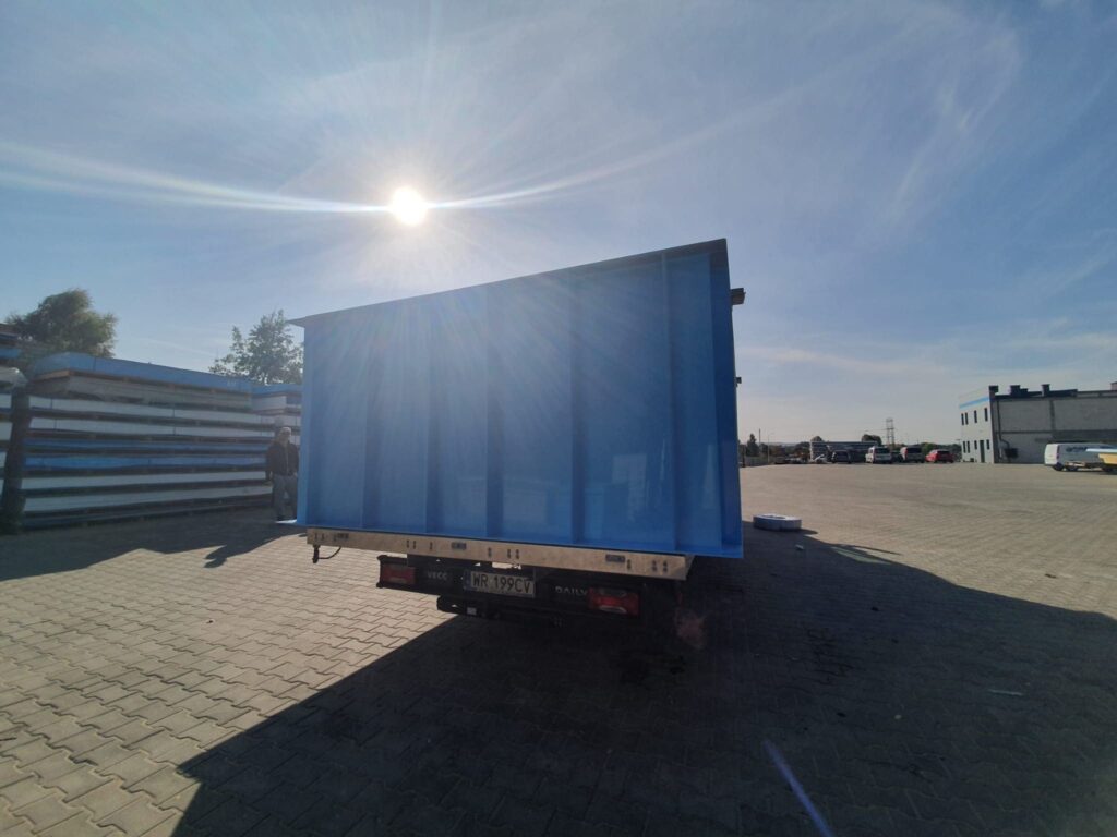 Duży niebieski basen jest ładowany na tył ciężarówki