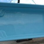 Duża, pusta, prostokątna niebieska muszla basenowa z wbudowanymi schodami.