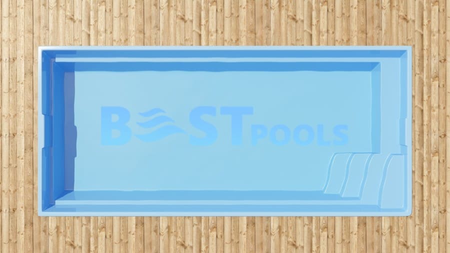Widok z góry na prostokątny, jasnoniebieski basen z trzema wbudowanymi schodkami na jednym końcu, ustawiony na drewnianym pomoście. Napis "BEST POOLS" jest słabo widoczny na dnie basenu.
