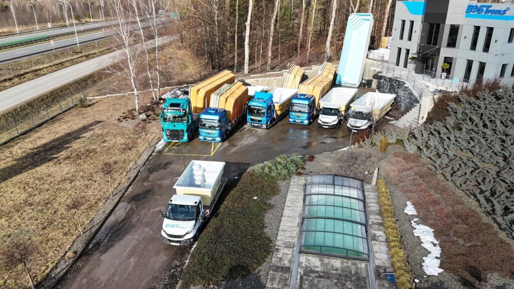 Flota ciężarówek przy budynku firmy