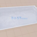 Prostokątny biały basen z zaokrąglonymi schodami na jednym końcu, umieszczony na beżowej powierzchni wyłożonej kafelkami; napis BEST POOLS jest słabo widoczny na dnie basenu.