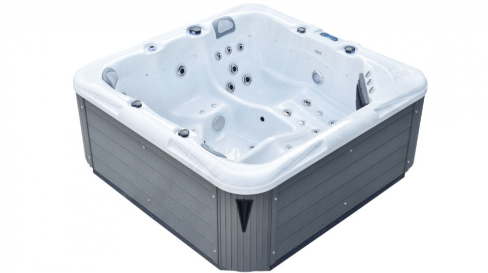 Duża, kwadratowa, zewnętrzna wanna z hydromasażem z szarymi panelami zewnętrznymi i białym wnętrzem, wyposażona w wiele wbudowanych siedzeń i dysz wodnych.