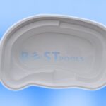 Biała powłoka basenu w kształcie nerki z wbudowanymi schodkami jest pokazana na niebieskim gradientowym tle z widocznym niewyraźnym napisem BEST POOLS.