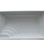 Prostokątna biała obudowa basenu widziana z góry, z trzema zakrzywionymi stopniami w jednym rogu prowadzącymi do basenu.