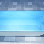 Prostokątny, naziemny basen z czystą, niebieską wodą i wbudowanymi schodami na jednym końcu.